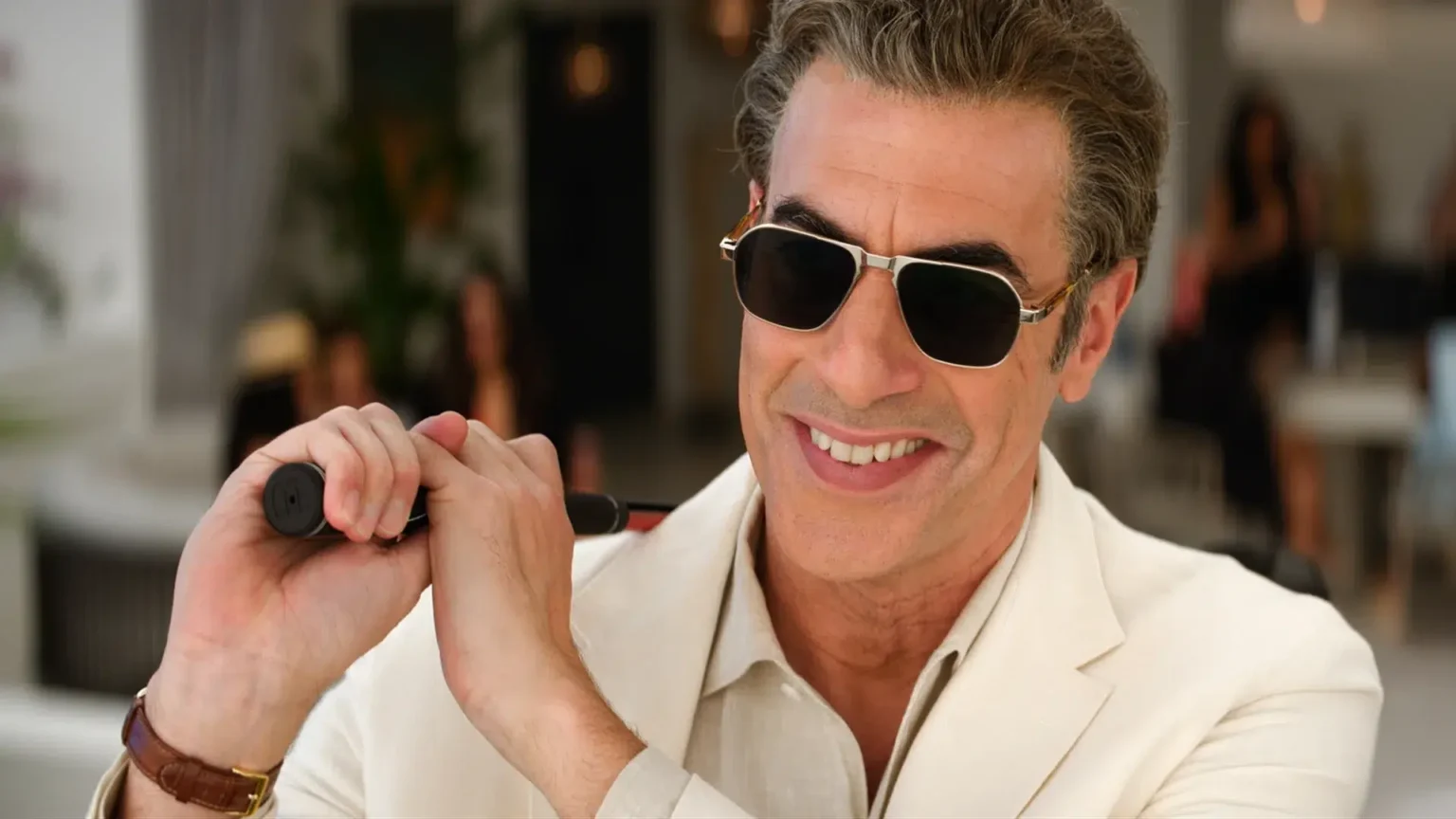remake com sacha baron cohen mostra o lado feminino do machismo em comédia divertida, mas previsível